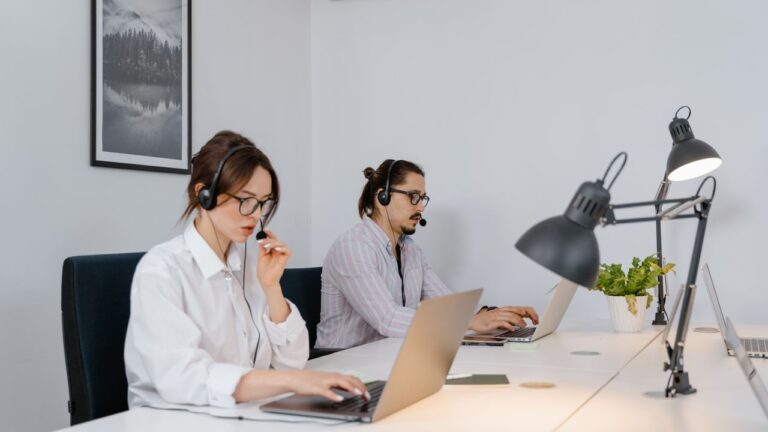 Support agents wearing headsets working at computers, representing white-label GoHighLevel support for agencies